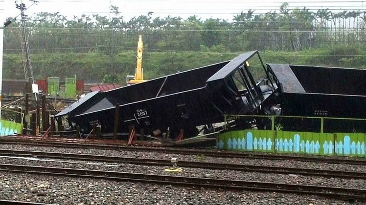 Train cars are seen swept off the tracks by cyclonic winds in Taitung City