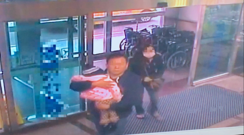 mother and father carry daughter to hospital