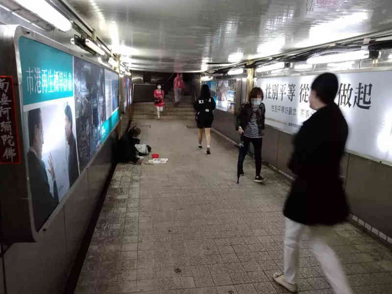 homeless person and pedestrians in underpass Keelung City
